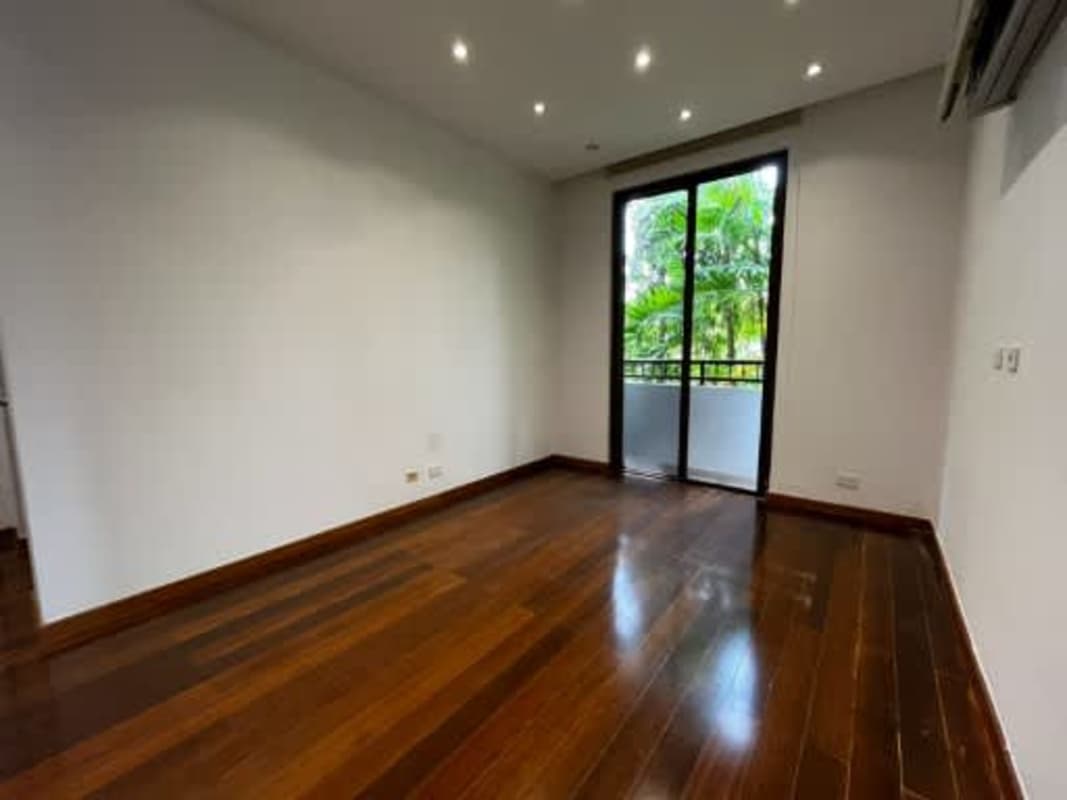 Bright bedroom wood flooring, sliding doors, balcony in Embassy Club Clayton home