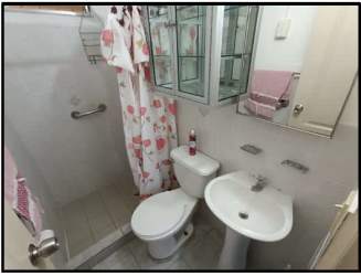 Bathroom with walk-in shower, pedestal sink, toilet, pink decor in La Chorrera home Villa del Carmen