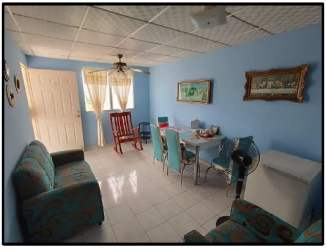 Blue painted wall living-dining room with tile floors, sofa, dining table in Panama Oeste house