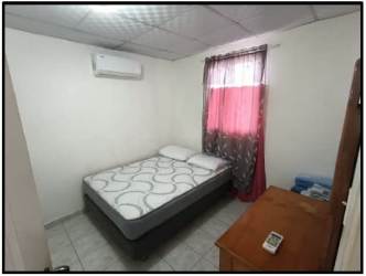 Simple bedroom with AC unit, pink curtains, tiled floor in Residencial Villa del Carmen house La Chorrera