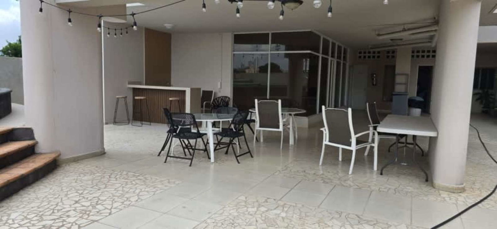 Covered entertainment patio with bar tables and columns in PH El Carmen Panama
