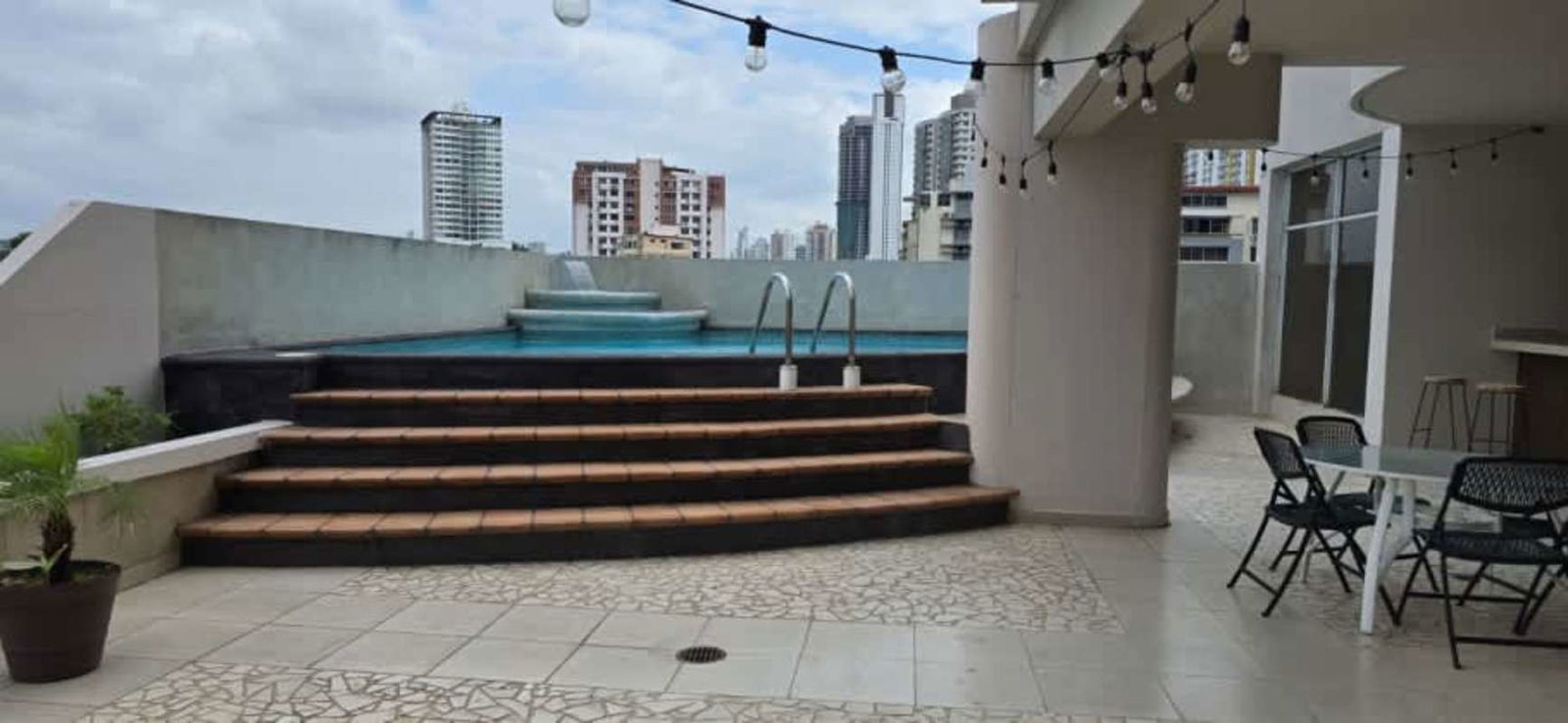Rooftop terrace with swimming pool, seating and skyline view at PH El Carmen Panama