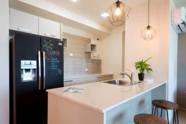 Modern open-plan kitchen and living room with balcony access and beachfront view in Playa Nueva Gorgona Panama