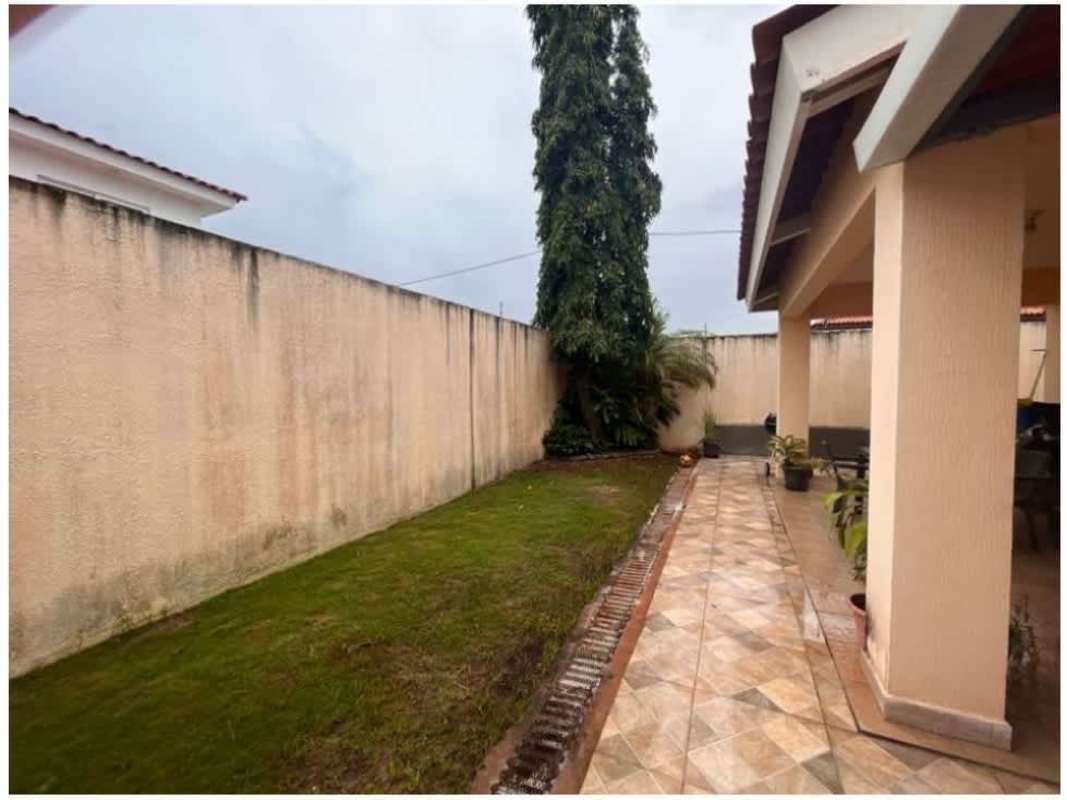 Bright living room with ceramic tile floor, AC, feature wall, and open stairway in Costa Sur house for sale PH Quintas de Versalles