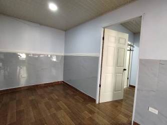 Modern bedroom with new wood tile flooring light blue walls Villa Liriola Cativa Colón apartment for rent