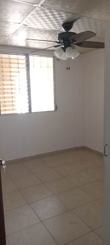 Bedroom with window, tiled floor, ceiling fan in Las Acacias apartment for sale