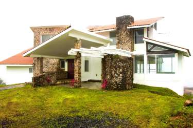 Beautiful mountain home with stone details sloped roof large windows and garden at Las Nubes El Valle