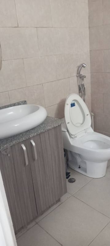 Contemporary bathroom with beige ceramic tiles, granite counter and modern fixtures in apartment PH Red Point
