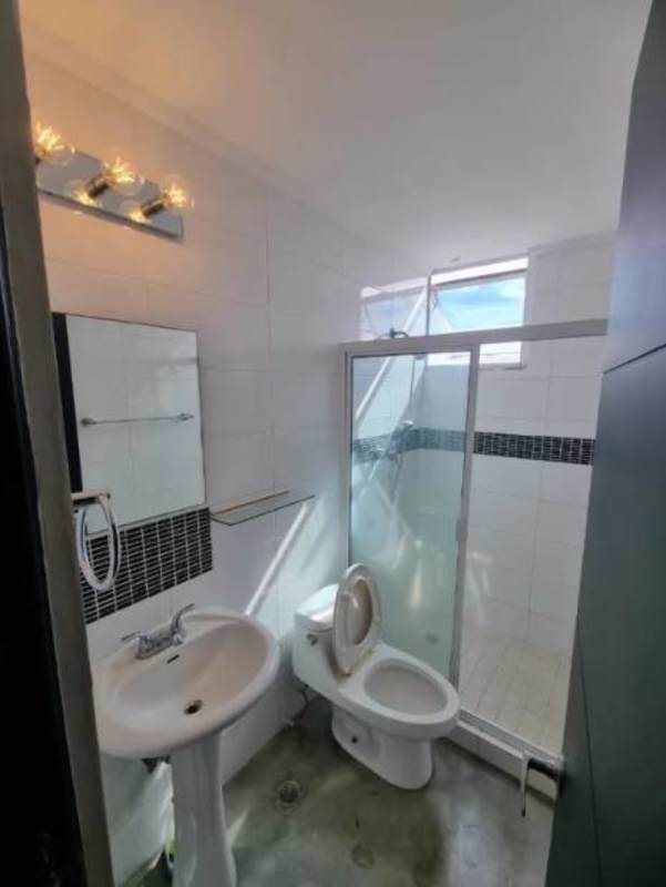 Sleek bathroom with pedestal sink, mirror, and walk-in glass shower at PH Park Lane Tower Panama