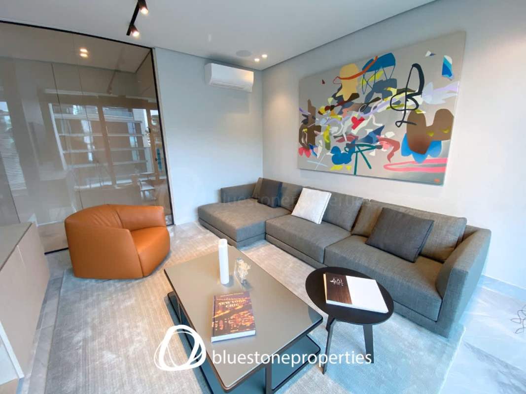 Modern living area with floor-to-ceiling windows showcasing golf and ocean views in Santa María Panama apartment