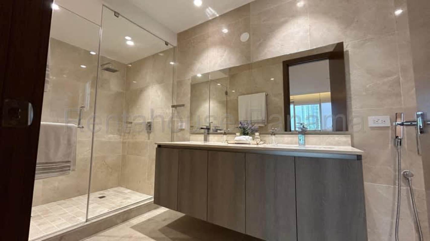 Modern bathroom with marble features and glass enclosed shower PH The Reserve Santa María Panama