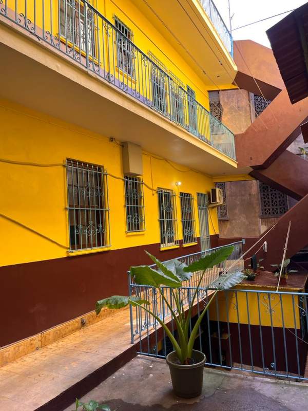 Brightly colored central courtyard with balconies and metal railings inside historic multifamily property