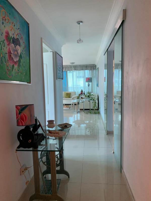 Spacious modern living room with white sofas, balcony access, pendant light fixtures in PH Mirador del Parque San Francisco Panama