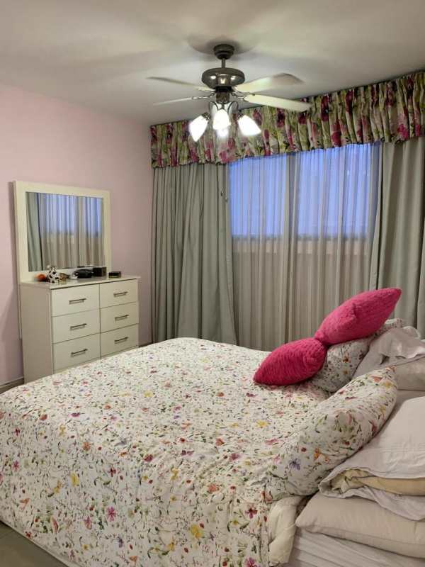 Traditional bedroom with large window and floral decor at PH Mirador del Parque Panama City