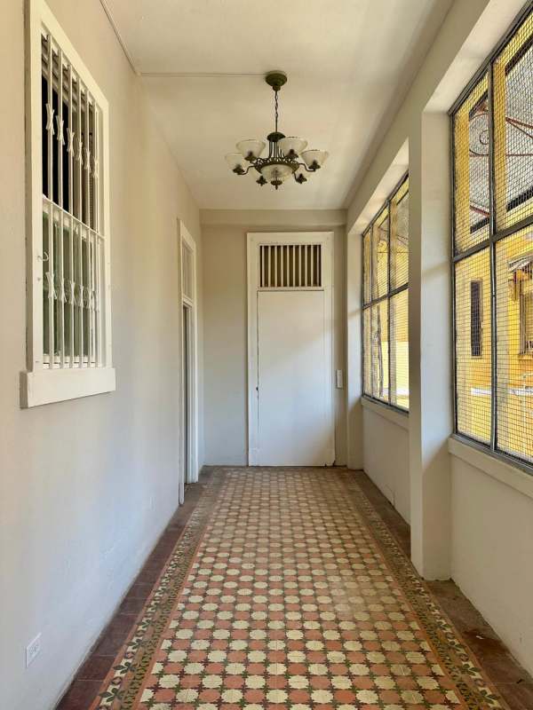 Bright corridor with vintage tile flooring and windows in Edificio El Dorado Santa Ana
