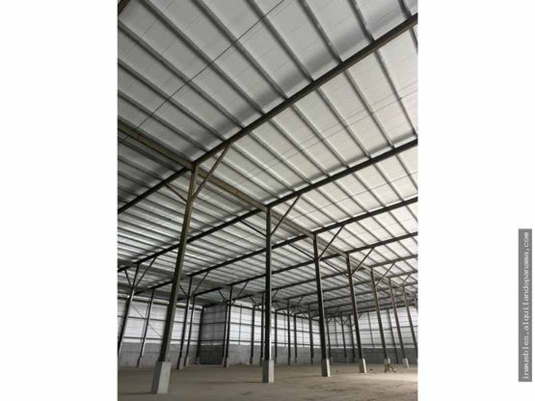 Interior of empty warehouse featuring tall ceilings steel beams industrial lighting Las Mañanitas Panama