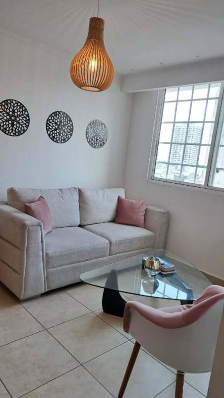Modern living room with beige sofa and pink accents at PH Palmeras Panama City