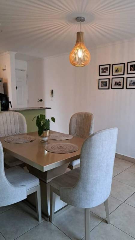 Modern dining room with pendant light, artwork, and tile flooring at PH Palmeras Panama