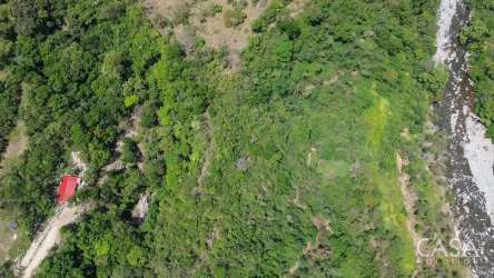 Panoramic aerial of riverfront farm with mountain backdrop in Gualaca Panama