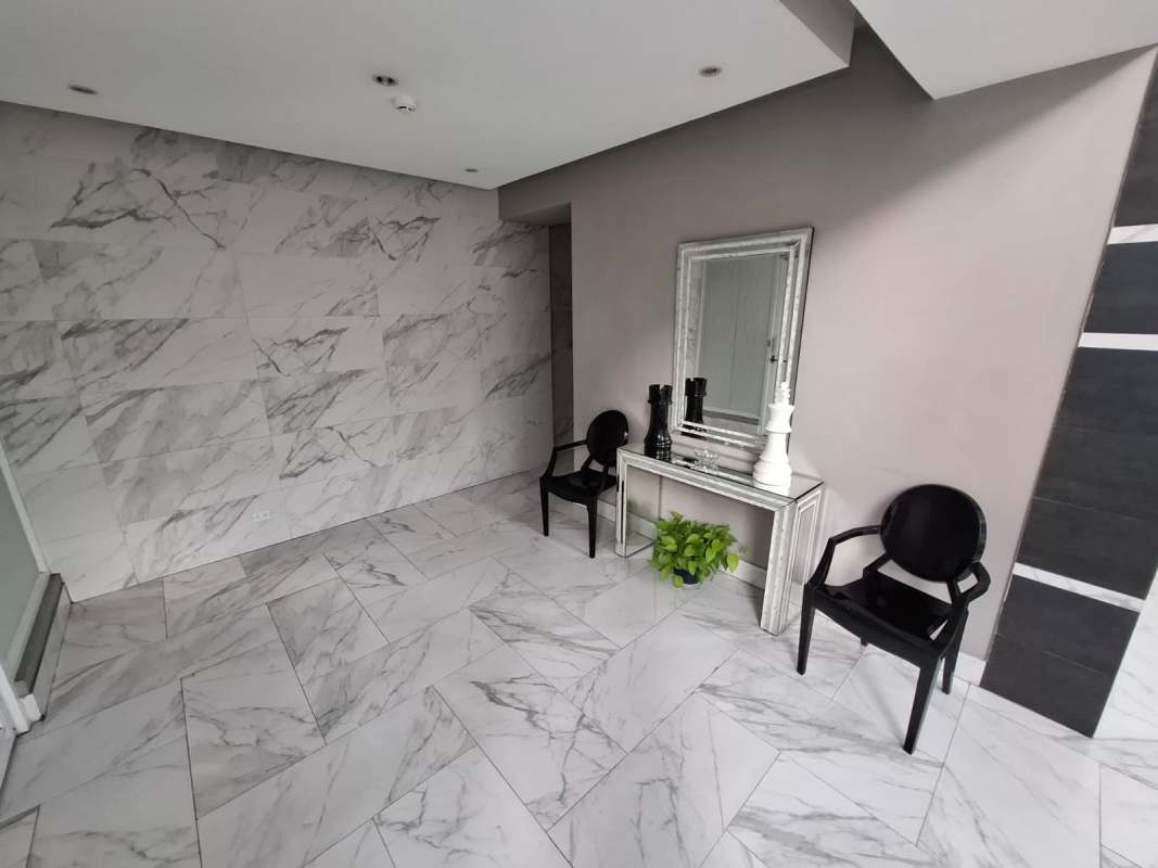 Modern kitchen with granite countertop, gas stove, and window in PH Vivendi Edison Park Panama City