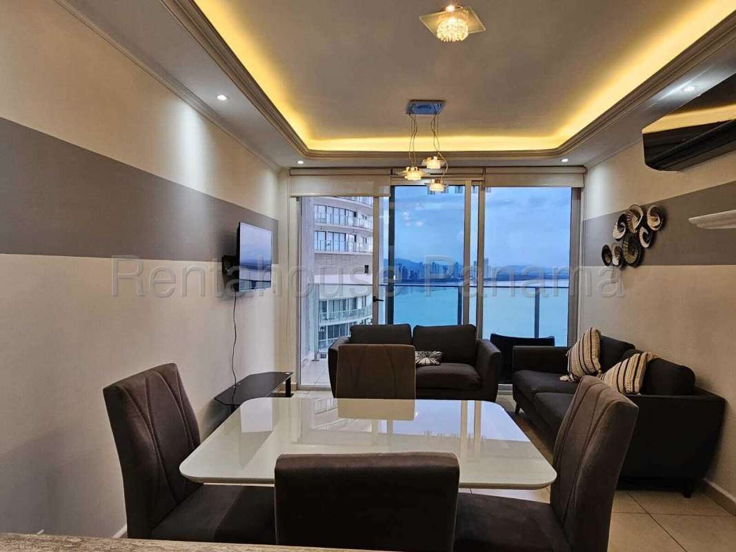 Modern living dining room with ocean city view wall-to-wall windows in Punta Pacifica apartment Panama