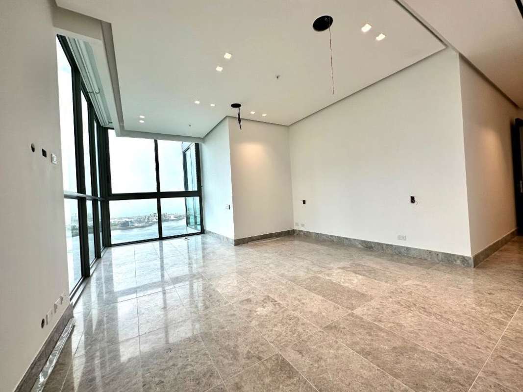 Contemporary bathroom with marble walls, oval mirror and sleek fixtures PH Punta Paitilla Panama City