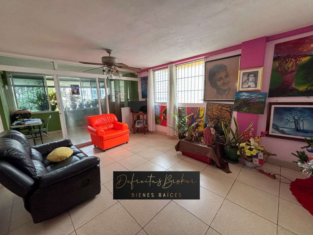 Eclectic living room with colorful art, ceiling fan, balcony access Parque Lefevre Panama apartment