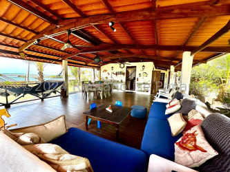 Rustic outdoor terrace with hammock, wood ceiling, lush garden and beach views in Costa Arriba Panama