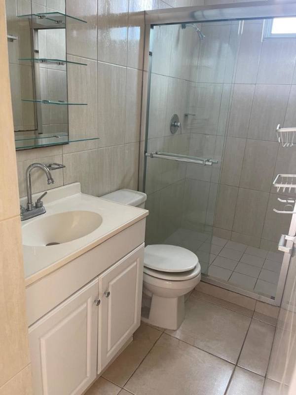 Modern bathroom with tiled walls, glass shower enclosure in apartment PH Residencial El Crisol Panama
