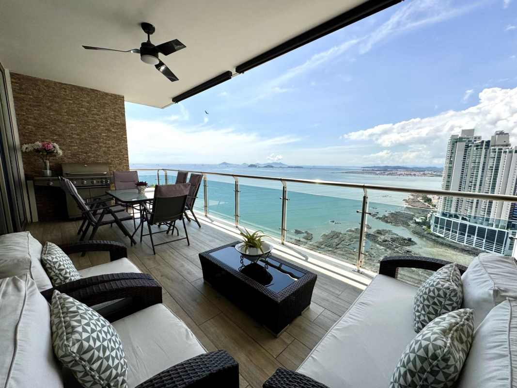 Marble floored living room with grand piano, floor to ceiling windows and ocean views in PH Aqualina Punta Pacifica Panama