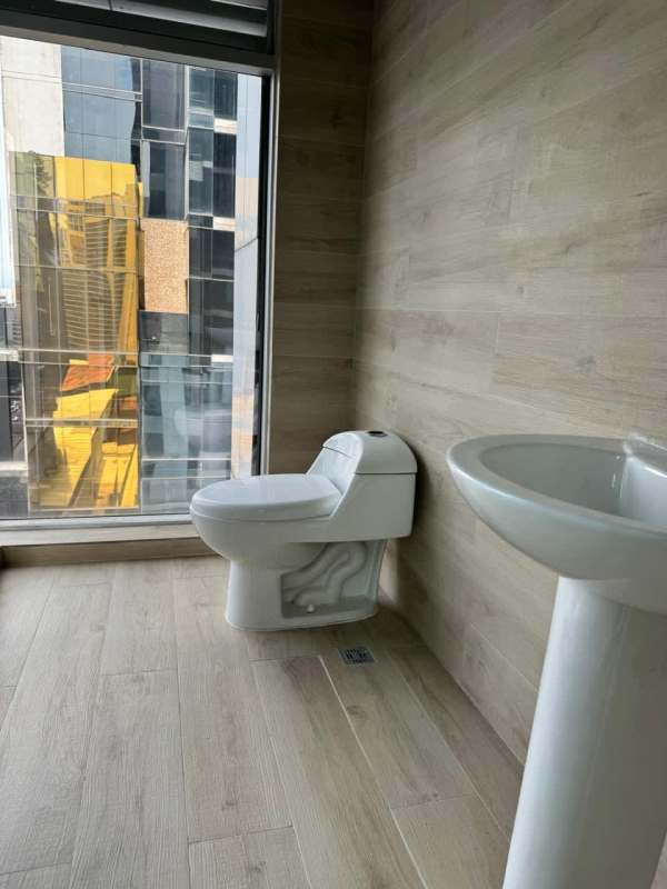 Minimalist bathroom with large window city view in commercial building Atrium Tower Obarrio Panama