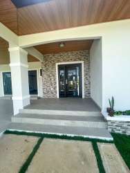 Contemporary entry porch with stone wall, double glass door, and landscaping in Boquete Chiriquí Panama