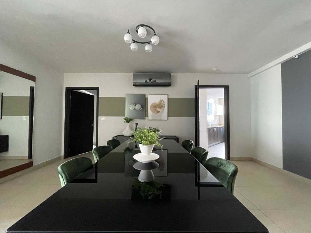 Elegant dining room with green velvet chairs, black glass table in PH Serenissima Costa del Este Panama
