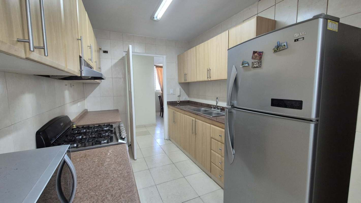 Bright enclosed kitchen with granite countertops, appliances and window light in PH Aurora Tower El Cangrejo