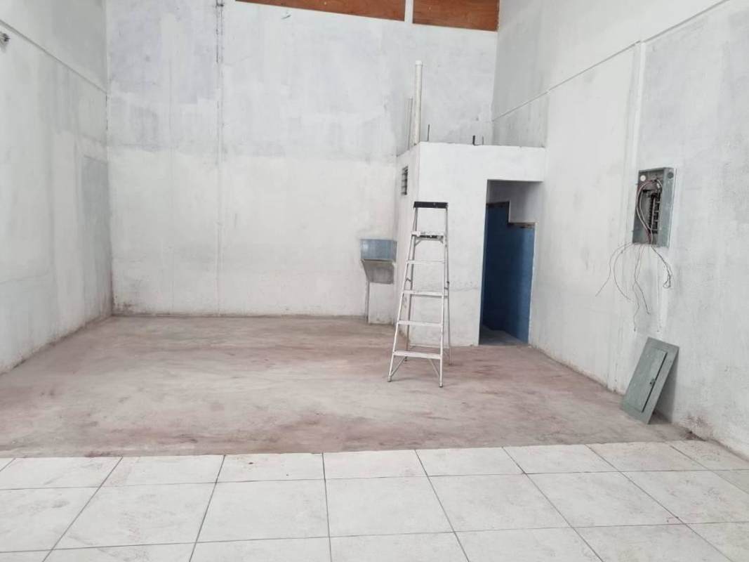Utility or storage room inside warehouse with high ceiling, exposed wiring, ladder Parque Lefevre Panama