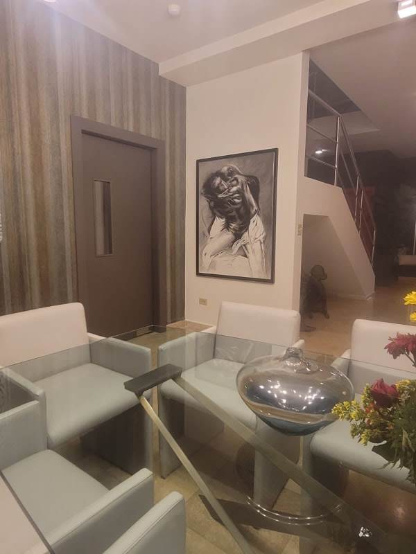 Contemporary dining area with glass table, chandelier, and panoramic window in Penthouse Punta Paitilla Panama City