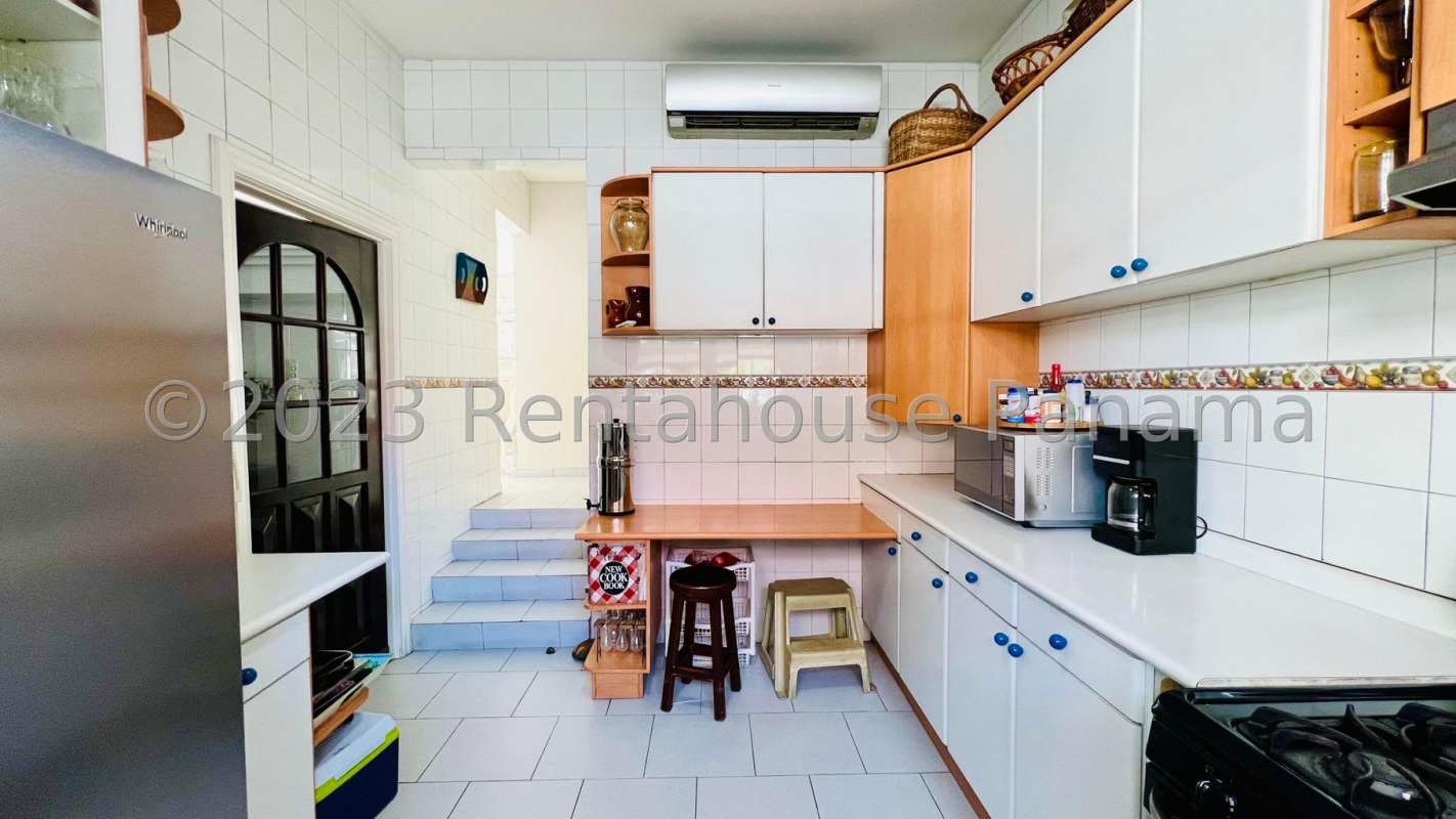 Traditional dining room with wood dining set, chandelier lighting and large window in Altos de Golf luxury house Panama
