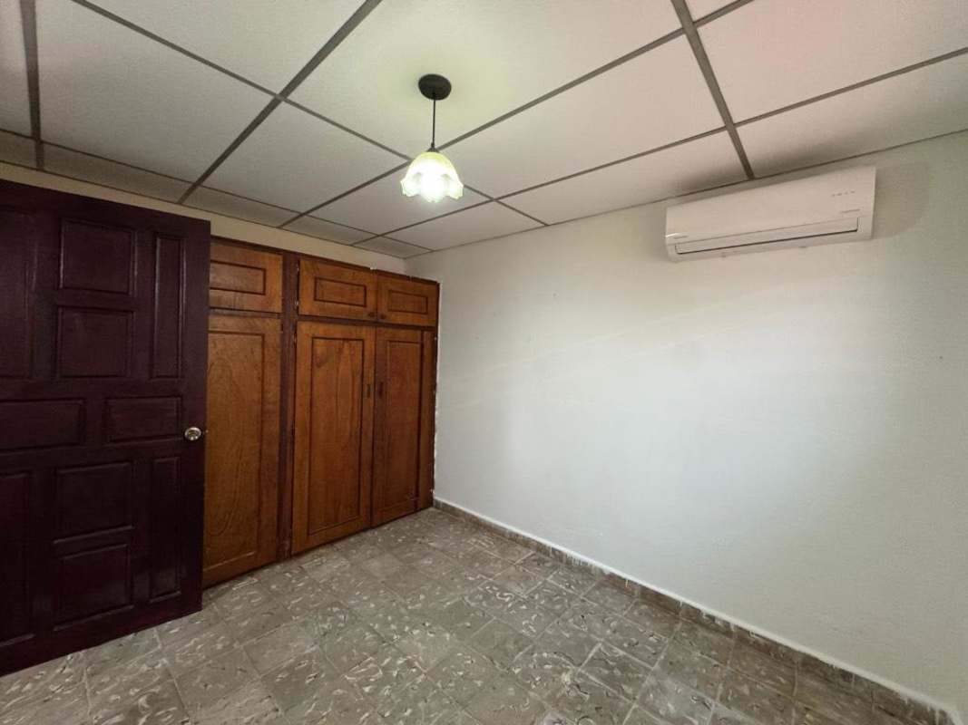 Bedroom with tiled floor, air conditioning, and security window bars in Colinas del Prado Panama City