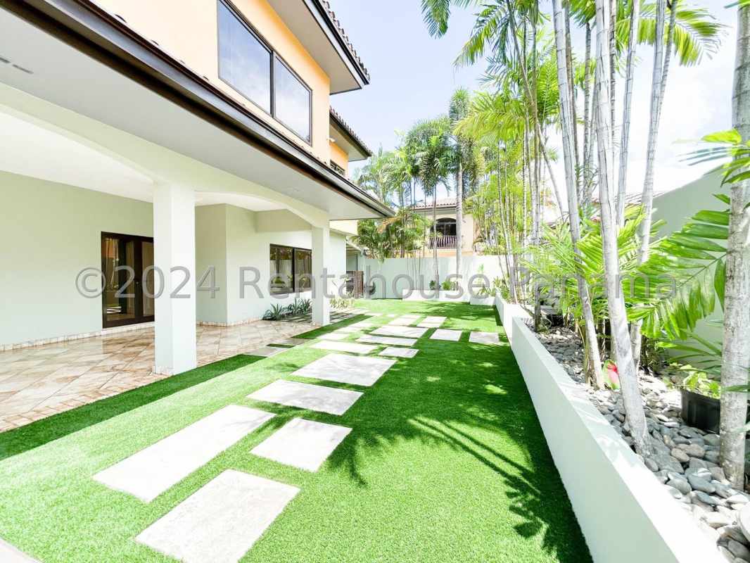 Swimming pool surrounded by tropical plants and well-manicured garden in Costa del Este luxury villa Panama