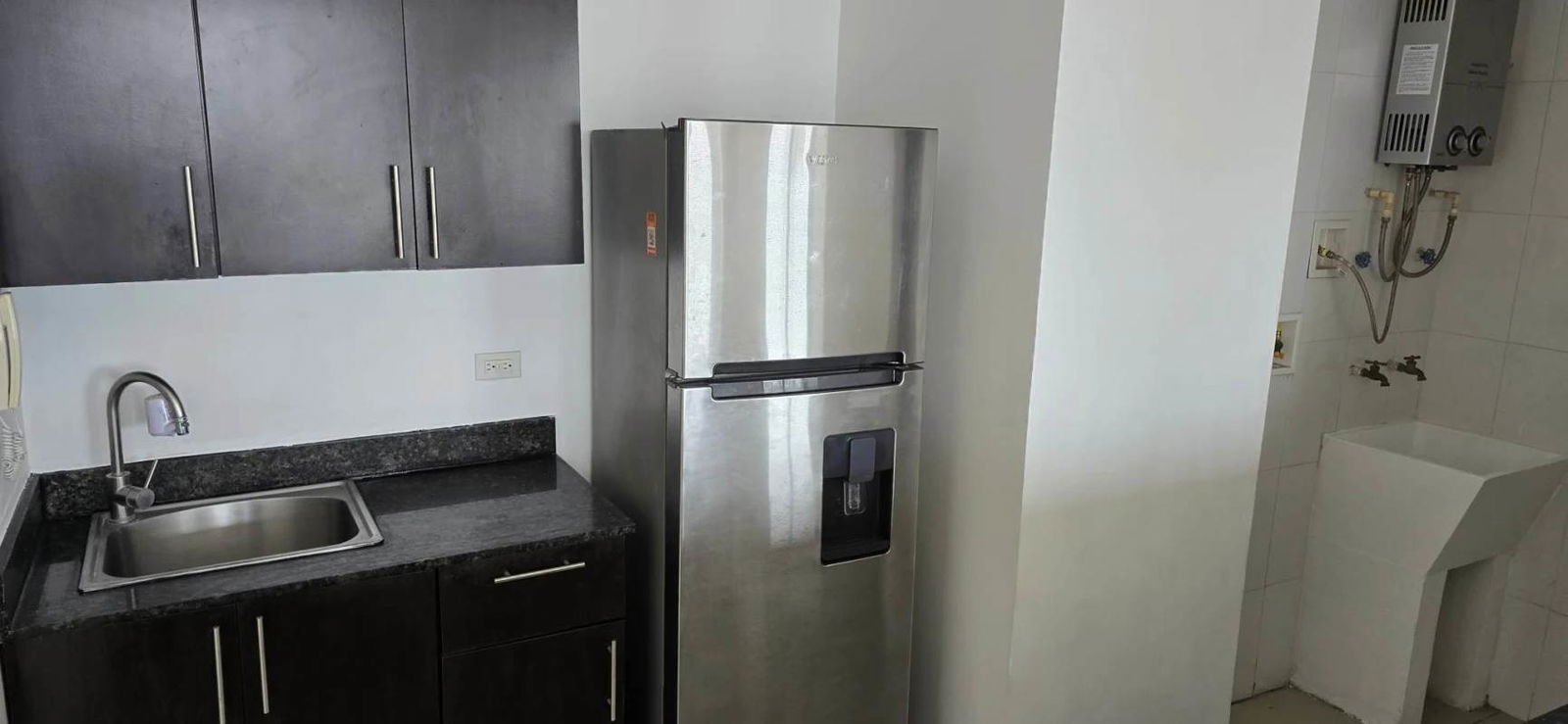 Kitchen with granite countertops and adjacent laundry in PH Macedonia Towers Panama City
