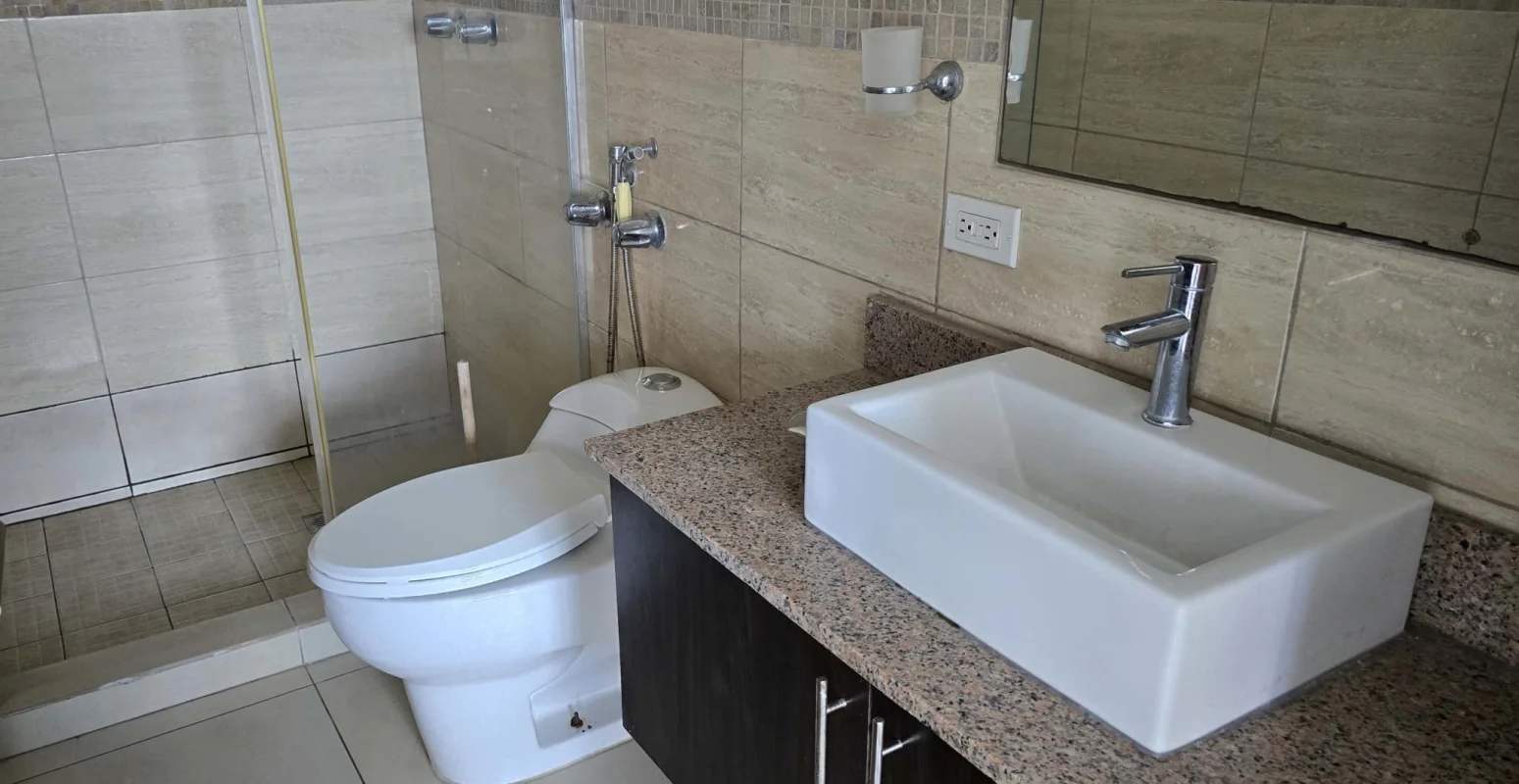 Elegant bathroom with glass shower and granite sink PH Macedonia Towers Panama City