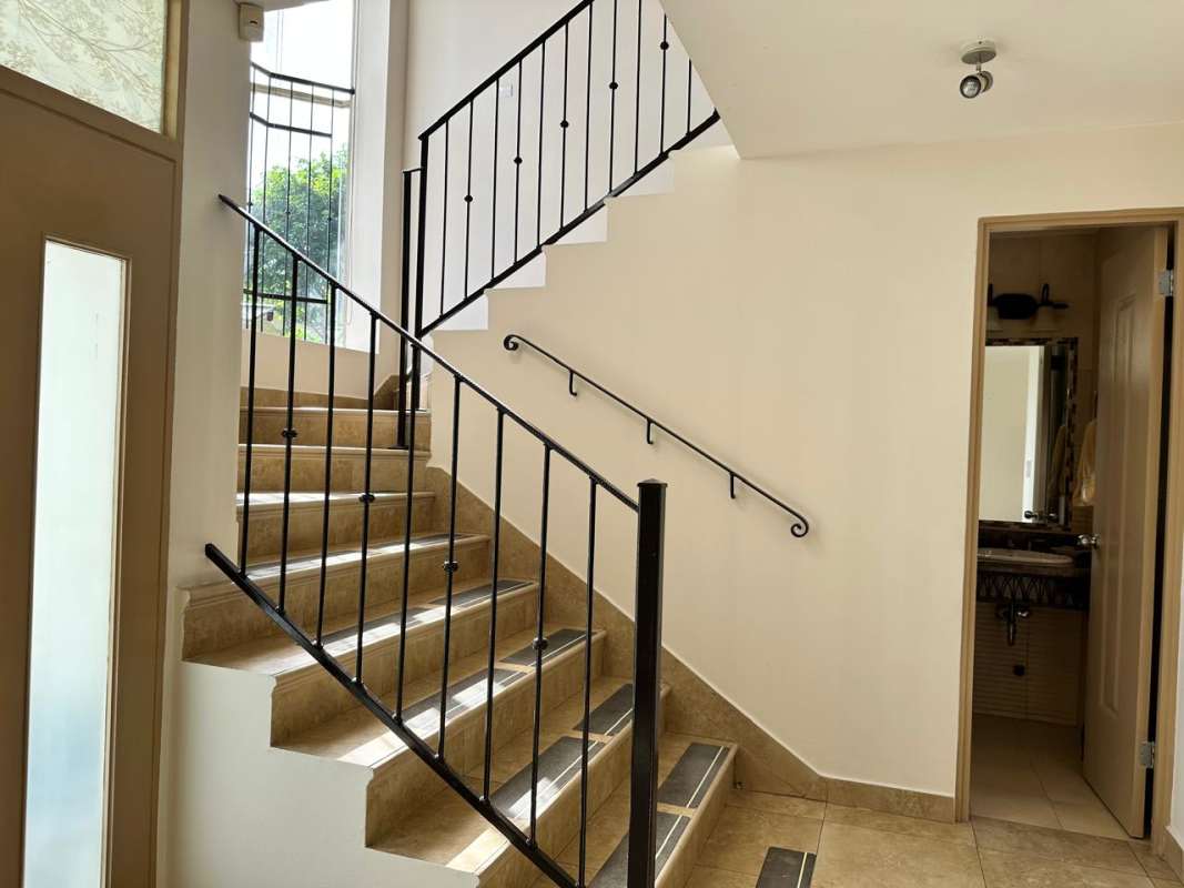 Interior staircase with metal railing and large windows in Clayton house for rent Panama