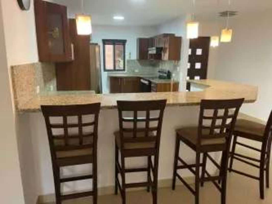 Contemporary kitchen with granite countertops and wood cabinets in Embassy Club Panama