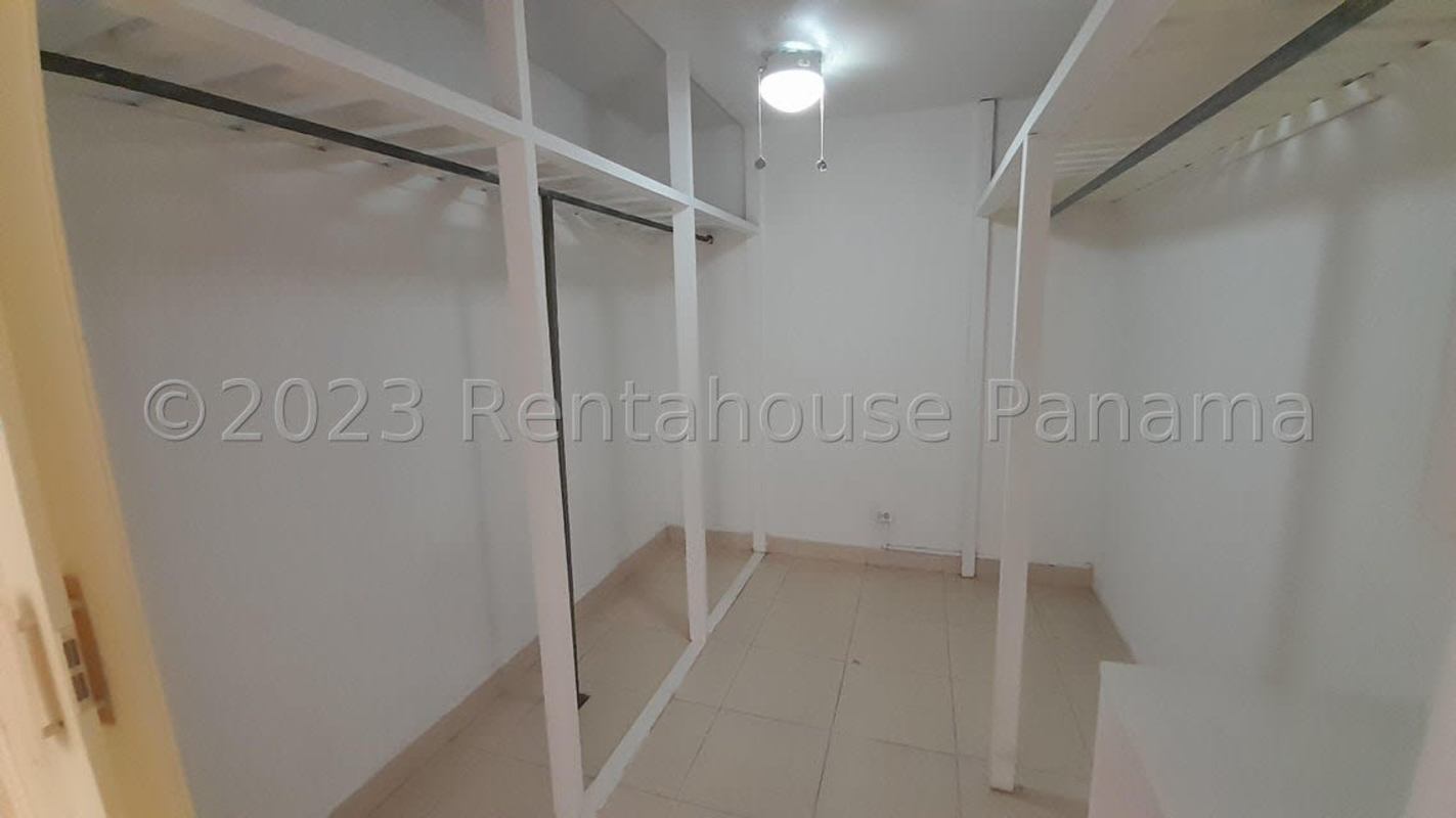 Large walk-in closet with open shelving, rails and tiled floor in house for sale El Bosque Condado del Rey Panama