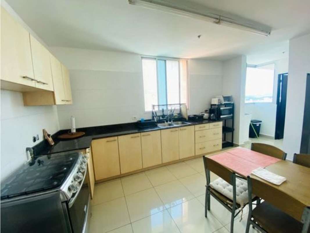Modern kitchen with granite counters, appliances, and dining area in PH Serenity Panama City
