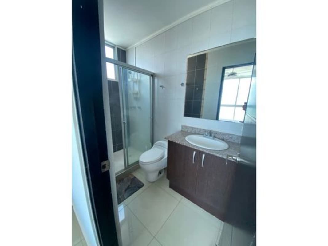 Bathroom with glass shower enclosure and marble vanity in PH Serenity Panama City