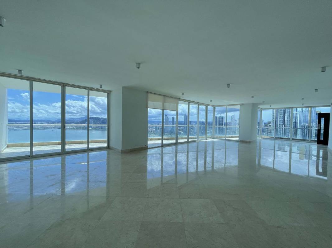Bright living room with marble floors, floor-to-ceiling windows and ocean view in The Point.