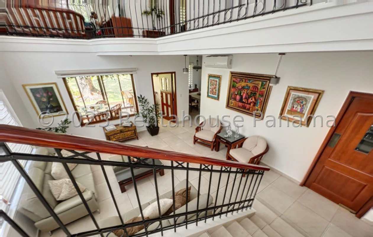 Private backyard swimming pool surrounded by lush landscaping and covered terrace in Los Senderos Clayton Panama