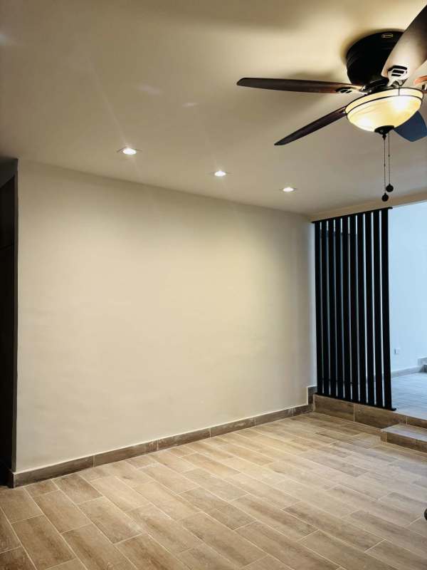 Spacious living room with open layout, ceiling fan in remodeled house in Altos de Golf Panama City