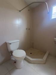 Concrete side path of rental home in Costa Oeste La Chorrera with fence and access gate